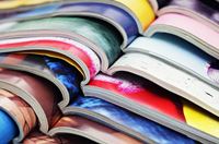 Several magazines displayed on a rack